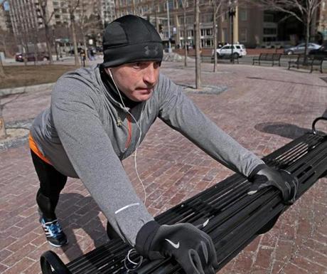 Peter Riddle stretched for a run along the Rose Fitzgerald Kennedy Greenway. He helped rescue a victim who lost a leg in the Boston Marathon bombings last year and struggles with post-traumatic stress disorder.
